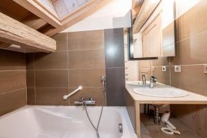 a bathroom with a tub and a sink at Le Galetas in Brides-les-Bains