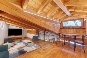 a living room with a wooden ceiling and a table at La Maison du Brenand in Rhêmes-Notre-Dame