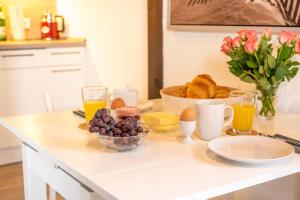 a table with a breakfast of bread and orange juice at Ferienwohnung Strandgut in Pellworm +2 photos