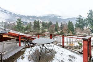 a table and chairs on a balcony with snow covered mountains at Le Galetas in Brides-les-Bains