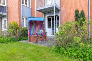 a colorful chair sitting in front of a building at Ferienwohnung Strandgut in Pellworm