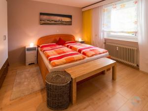 a bedroom with a bed and a bench and a window at Ferienwohnung Knopf in Schömberg
