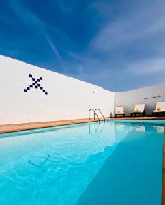 a swimming pool with chairs next to a building at Lanzarote Suite Moon in Tías