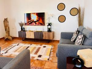 a living room with a couch and a tv on a wall at Lanzarote Suite Moon in Tías
