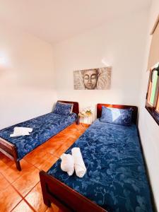 a bedroom with two beds and a painting on the wall at Lanzarote Suite Moon in Tías +21 photos