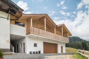 a house with a balcony on top of it at Blosegghof Bergchalets Talblick in Racines