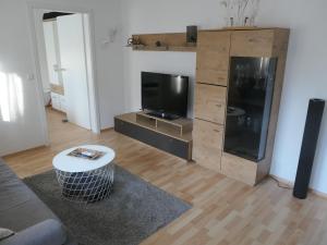 a living room with a large wooden entertainment center with a flat screen tv at Ferienwohnung Schneckenhaus in Ofterdingen