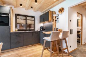a kitchen with gray cabinets and a table and chairs at Blosegghof Bergchalets Talblick in Racines