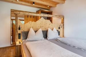 a bedroom with a bed with a wooden headboard at Blosegghof Bergchalets Talblick in Racines