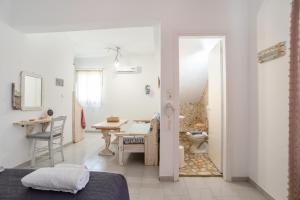 a room with a bed and a table and a bathroom at Green Retreats 4 Paros in Isterni +12 photos