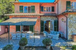 an outdoor patio with chairs and tables in front of a house at Villa Les Ombrelles in Portoferraio