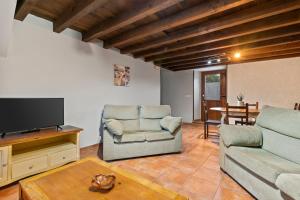 a living room with two chairs and a flat screen tv at Esteiro in Céltigos