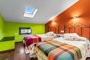 two beds in a room with green and orange walls at Esteiro in Céltigos