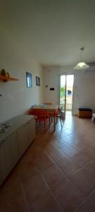a living room with a table and a tiled floor at Villetta Nicola in Salve