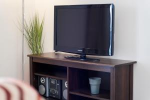 a television sitting on top of a wooden stand at Villa Votistis A1 in Lefkada
