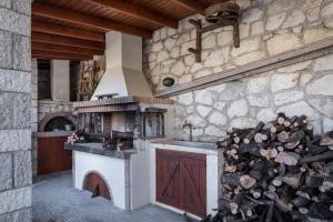 a kitchen with a stove and a pile of logs at Villa Votistis A1 in Lefkada