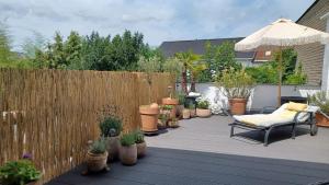 a patio with potted plants and a wooden fence at Ferienwohnung Beletage mit Terrasse in Neuwied