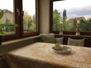 a table with a plate on it in a room with windows at Ferienwohnung Beletage mit Terrasse in Neuwied +22 photos