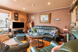 a living room with a leather couch and a table at Ferienhaus Nahe Ostsee in Rövershagen