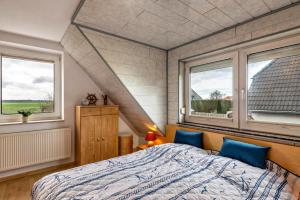 a bedroom with a bed and two windows at Ferienhaus Nahe Ostsee in Rövershagen