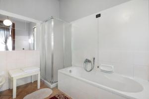 a white bathroom with a tub and a shower at Wakesurfhouse in Sulzano +23 photos