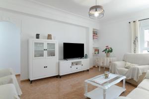 a white living room with a flat screen tv at Céntrico apartamento en Tarifa in Tarifa