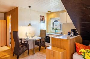a kitchen and dining room with a table and chairs at Ferienwohnung Klee 2 in Fedderwarden