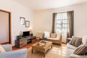 a living room with a couch and a tv at Casa da Olides - T3 and Studio in Santana