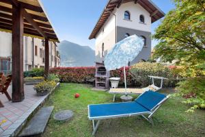 a yard with a blue chair and an umbrella at Wakesurfhouse in Sulzano