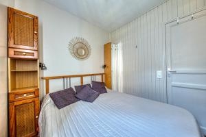 a bedroom with a bed with purple pillows at Maisonnette Botticelli - Ares in Arès