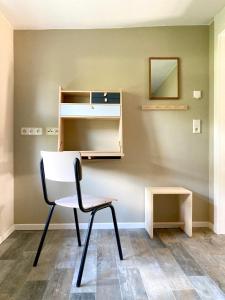 a chair in a room with a desk and a mirror at Bungalow 314 in Joachimsthal