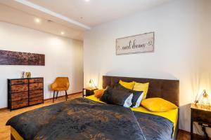 a bedroom with a large bed with yellow pillows at Gästewohnung Auszeit in Regis-Breitingen