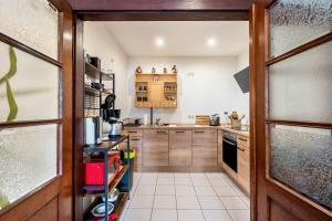 a kitchen with wooden cabinets and a door open at Gästewohnung Auszeit in Regis-Breitingen