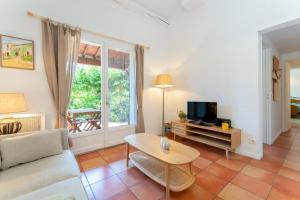 a living room with a couch and a table and a tv at Lou Cigaloun in Bédoin