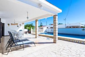 a patio with a table and chairs and a swimming pool at Sorpresa in Vinarós