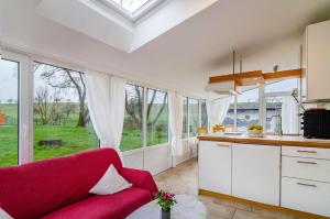 a kitchen with a red couch in a room with windows at Haus Nussbaum in Hödingen