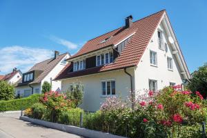 a white house with a red roof at Haus Sonnenschein in Eriskirch