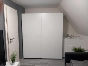 a large white cabinet in a living room at Ferienwohnung Conrads in Zetel