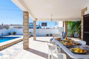 a patio with a table and chairs and a swimming pool at Sorpresa in Vinarós