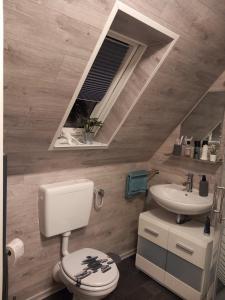 a bathroom with a toilet and a sink at Ferienwohnung Conrads in Zetel