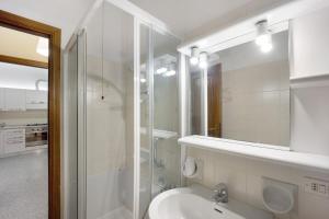 a white bathroom with a shower and a sink at Appartamento Orizzonte 8 B in Diano Marina +17 photos
