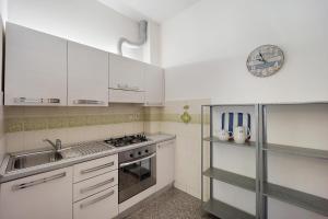 a kitchen with white cabinets and a sink at Appartamento Orizzonte 8 B in Diano Marina