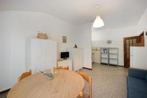 a dining room with a wooden table and a blue couch at Appartamento Orizzonte 8 B in Diano Marina