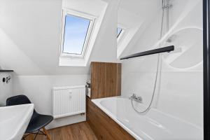 a bathroom with a white tub and a shower at Apartment Lio - See und Zentrum in Friedrichshafen +18 photos