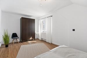 a bedroom with a bed and a chair and a window at Apartment Lio - See und Zentrum in Friedrichshafen