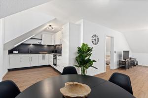 a kitchen and dining room with a table and chairs at Apartment Lio - See und Zentrum in Friedrichshafen