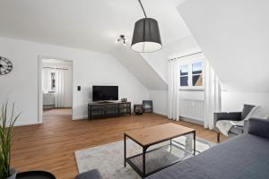 a living room with a couch and a table at Apartment Lio - See und Zentrum in Friedrichshafen