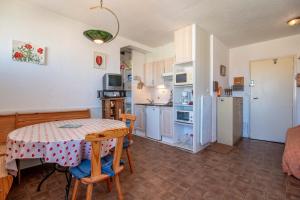 a kitchen and dining room with a table and a kitchen with white appliances at Grand Hotel Studio in Valras-Plage +14 photos