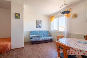 a living room with a blue couch and a table at Grand Hotel Studio in Valras-Plage