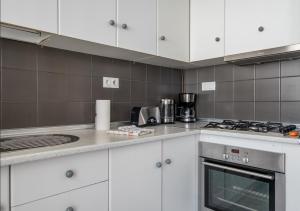 a kitchen with white cabinets and a stove top oven at Flat3-5 Chaparil Beach in Nerja